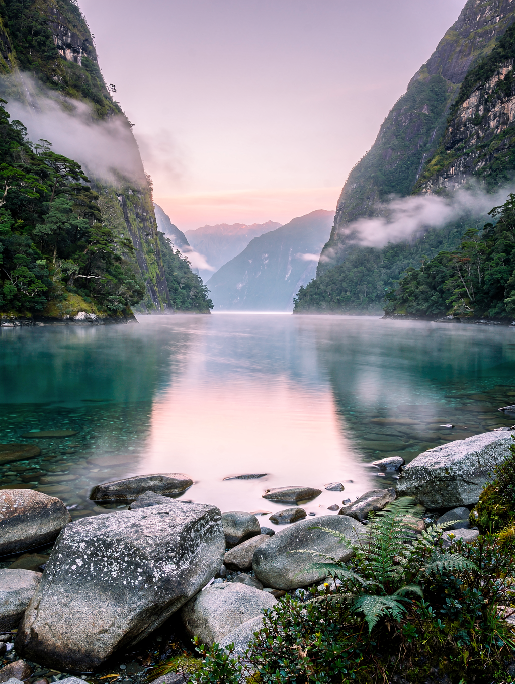 Steep cliffs plunging into deep fiord waters